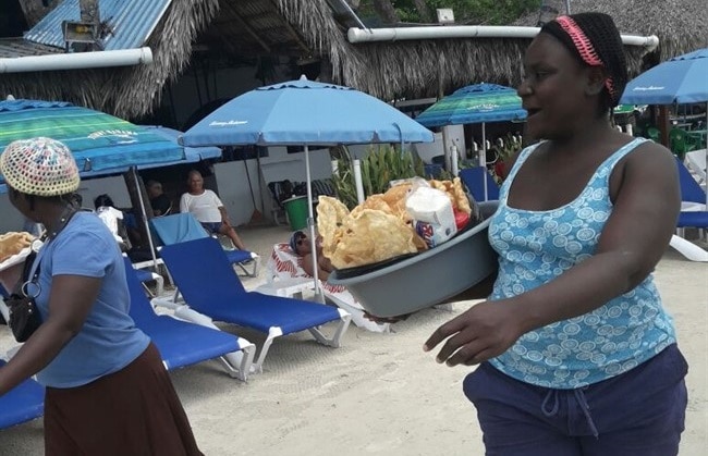 מלצרית בחופי בוקה צ'יקה מגישה אוכל דומיניקני לתיירים