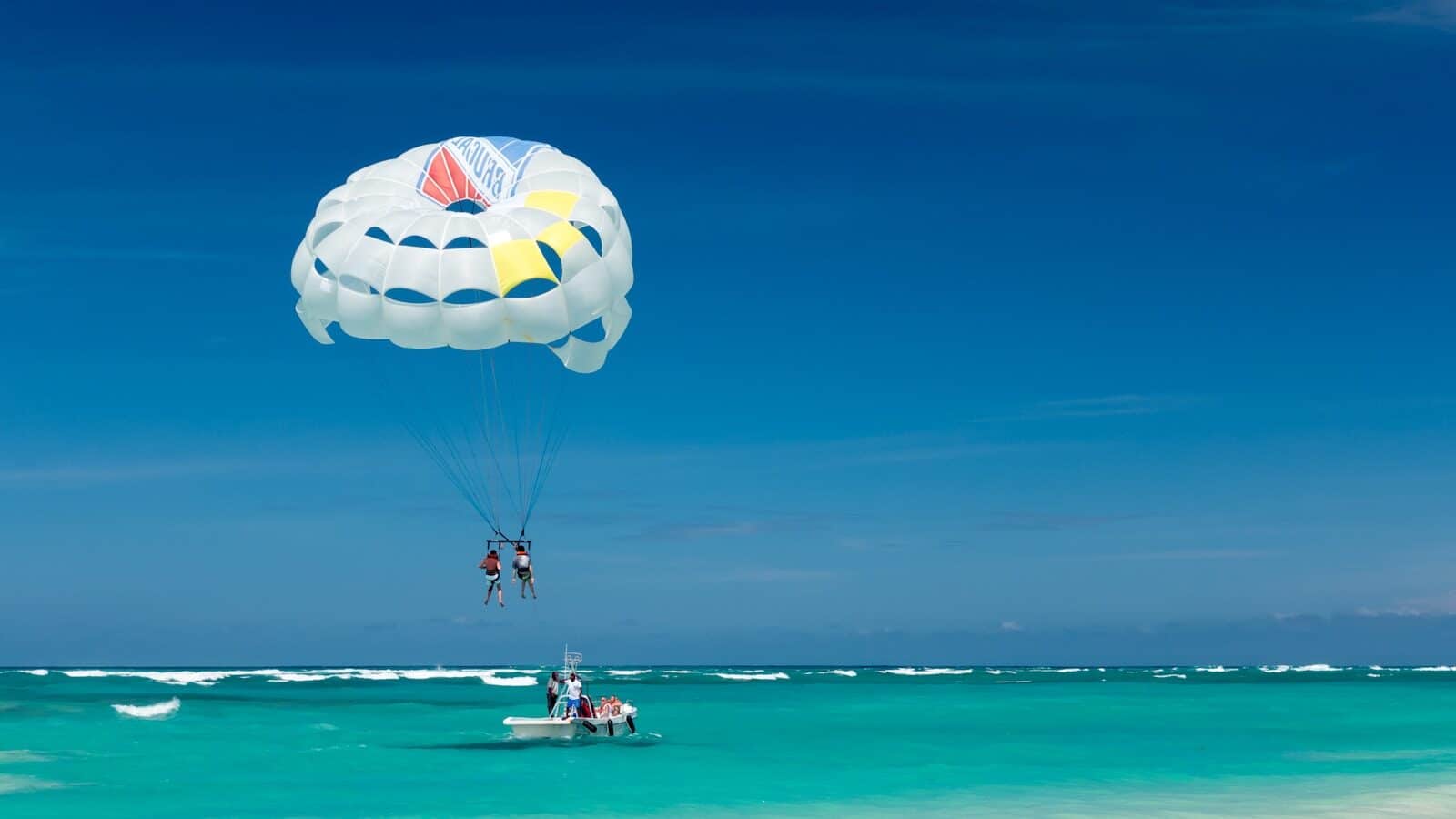 ספורט ימי ברפובליקה הדומיניקנית two person riding parachute near beach